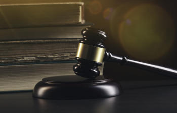 Open law book with a wooden judges gavel on table