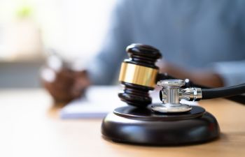 Judge's gavel and a stethoscope on a medical malpractice attorney's desk.