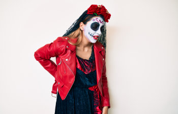 woman wearing day of the dead costume over white suffering of backache