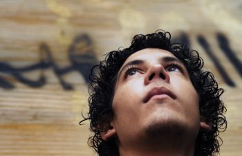 Portrait of young hispanic teen boy against grunge background